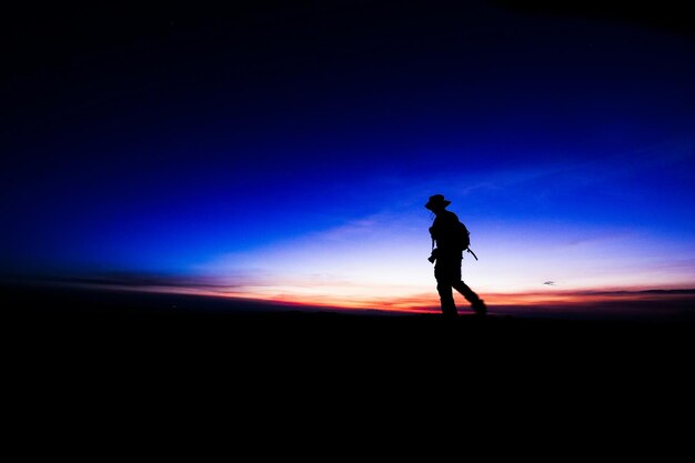 Foto silhouet mensen staan op het landschap bij zonsondergang
