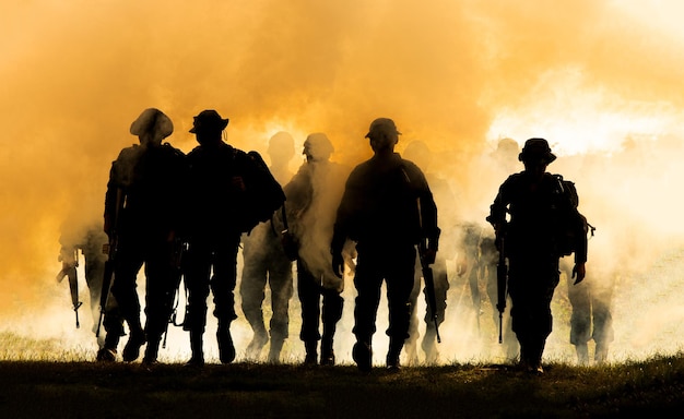 Silhouet mensen staan op het veld tegen de hemel tijdens de zonsondergang
