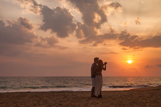 Silhouet mooi paar hand in hand op tropisch zandstrand op zee zonsondergang achtergrond gelukkig man en vrouw dansen geluk