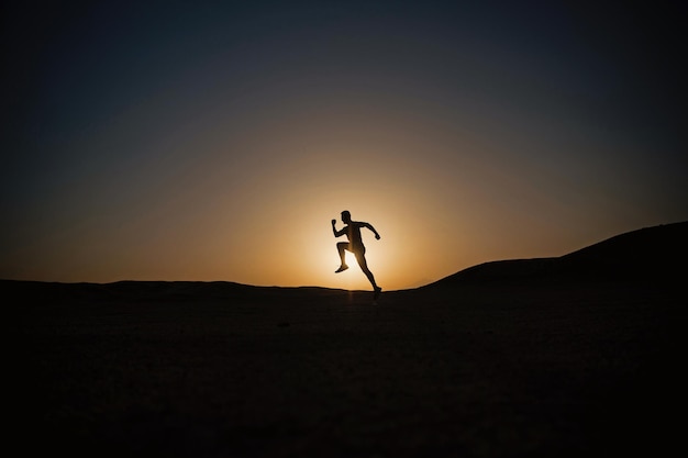 Silhouet of man runner man loopt buiten bij heldere hemel