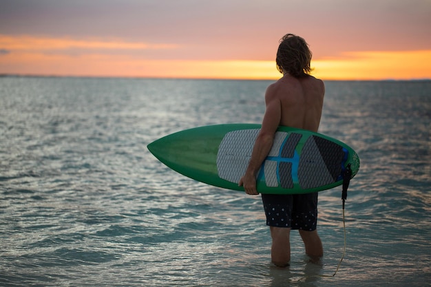 Silhouet paddle board surfer op de zonsondergang achtergrond