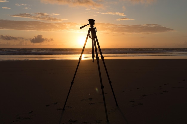 Foto silhouet persoon fotografeert op het strand tegen de hemel tijdens de zonsondergang