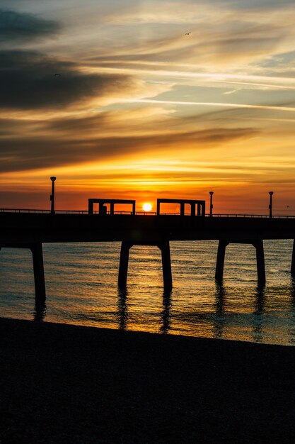 Foto silhouet pier over zee tegen de hemel tijdens zonsopgang