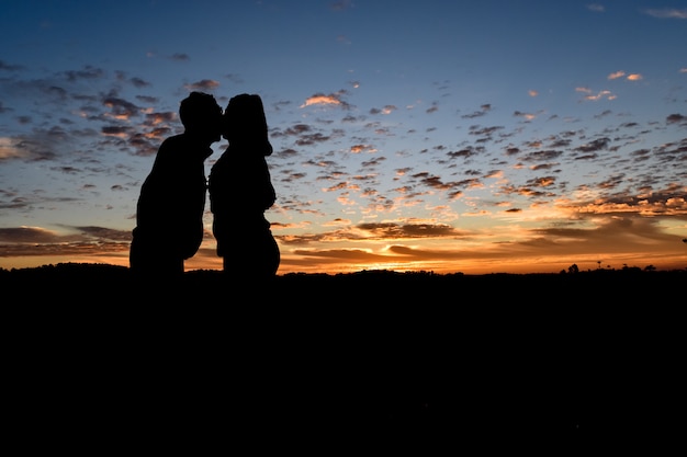 Silhouet romantisch paar in liefde, man en vrouwen in aard, hemel met wolk in zonsopgangtijd.