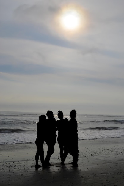 Silhouet van 4 vrouwen op een strand bij zonsondergang