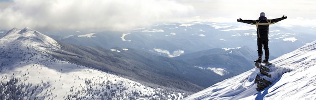 Silhouet van alleen toerist die zich op besneeuwde bergtop bevindt