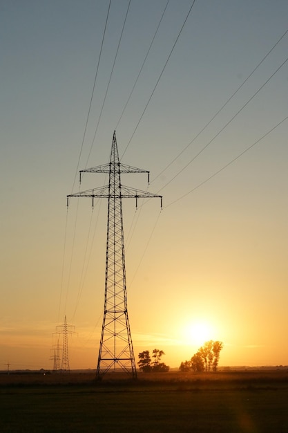 Silhouet van de elektriciteitspylon bij zonsondergang