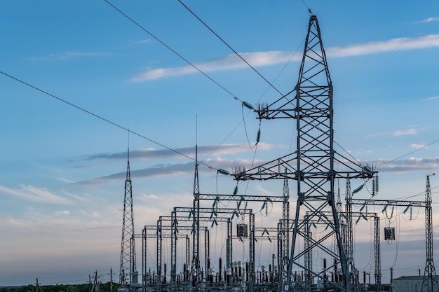 Silhouet van de elektrische hoogspanningsmasten op de achtergrond van mooie avondwolken