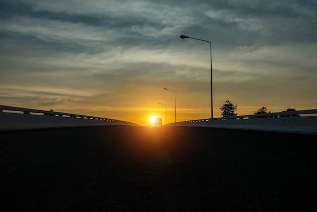 Silhouet van een auto op de hemelachtergrond bij zonsondergang