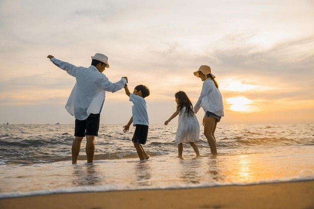 Silhouet van een familie die elkaar de hand houdt en een gezonde levensstijl heeft op het strand