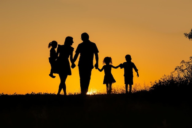 Silhouet van een gezin met kinderen bij zonsondergang