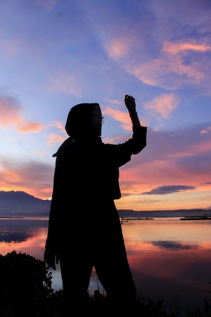 Silhouet van een jonge vrouw die zich voordeed tegen een prachtige zonsondergang op de achtergrond