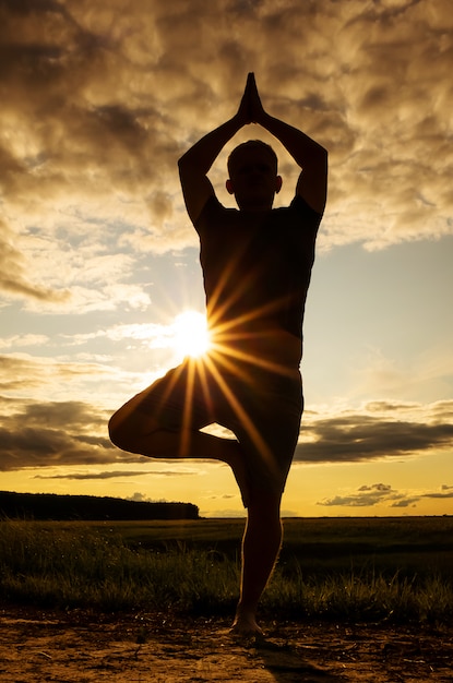 Silhouet van een man die aan yoga doet