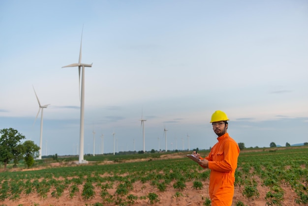 Silhouet van een man-ingenieur die werkt en het rapport vasthoudt bij het Power Generator Station van het windturbinepark op mensen in bergThailand