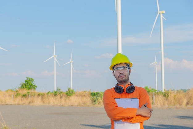 Silhouet van een man-ingenieur die werkt en het rapport vasthoudt bij het Power Generator Station van het windturbinepark op mensen in bergThailand
