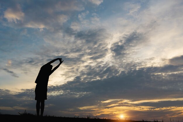 Silhouet van een man met een man die traint in de zonsondergang.