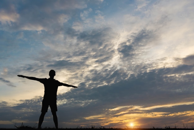 Silhouet van een man met man die traint in de zonsondergang.