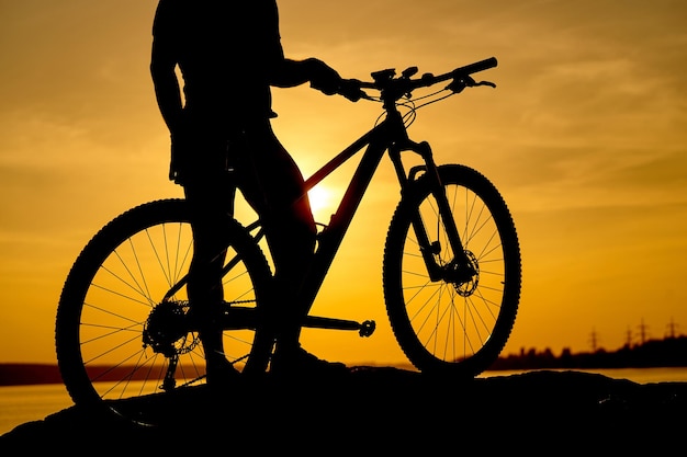 Silhouet van een man op mountainbike zonsondergang
