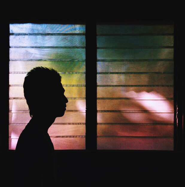 Foto silhouet van een man tegen een raam.