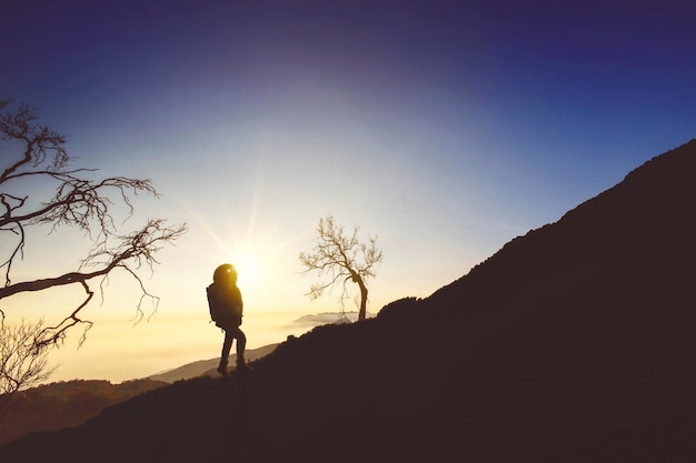 Silhouet van een mannelijke wandelaar die geniet van de zonsopgang