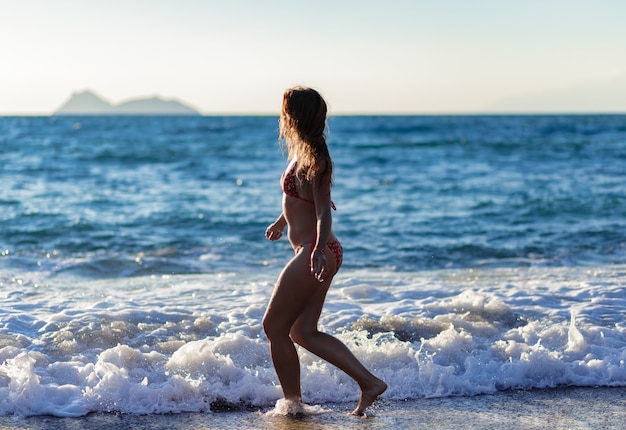Silhouet van een meisje dat op het strand van matala . loopt
