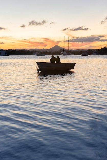 Silhouet van een paar zittend in een boot kijkend naar de zonsondergang in Noosa River QueenslandAustralia