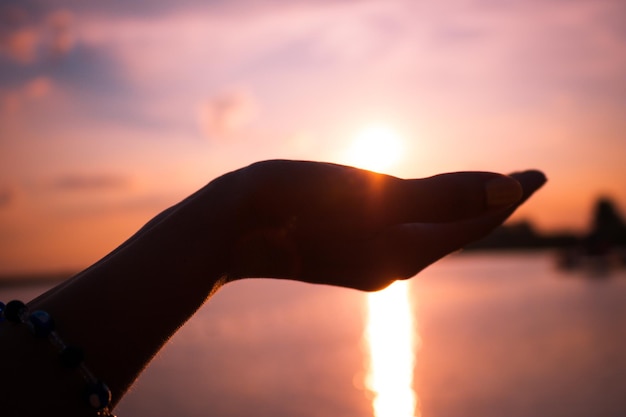 Foto silhouet van een persoon aan zee tegen de zon in de lucht bij zonsondergang