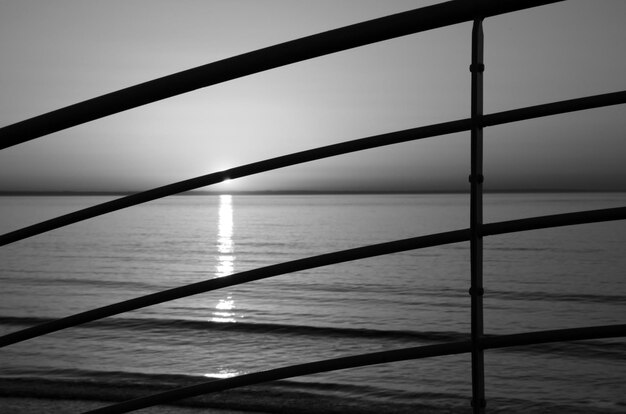 Foto silhouet van een reling met de zee op de achtergrond