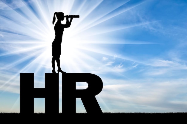 Silhouet van een vrouw die op de letters HR staat en door een verrekijker kijkt op zoek naar potentiële werknemers. Inhuur concept
