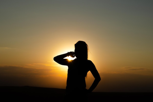 Silhouet van een vrouw tegen de zonsondergang