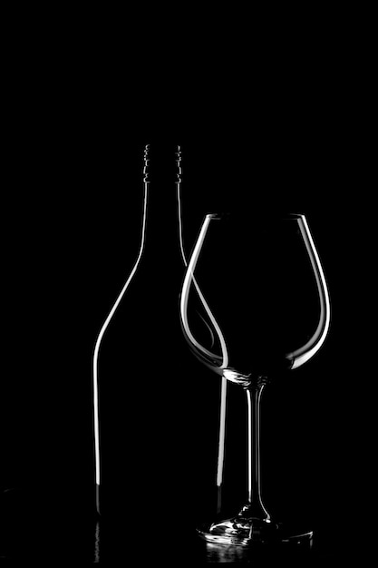 Silhouet van een wijnfles en een wijnglas op zwarte achtergrond