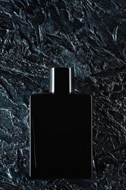 Silhouet van een zwarte fles eau de toilette voor mannen op een donkere achtergrond Reclamefoto van parfums Donkere stijl