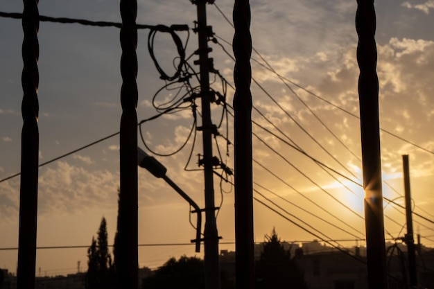 Silhouet van elektrische lijnen vezelkabels knooppunt en licht op het gouden uur