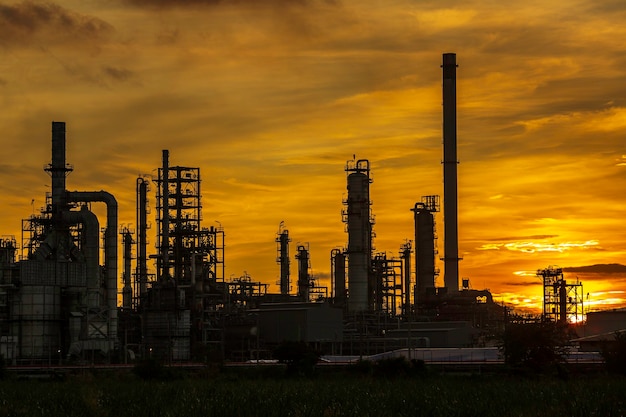 Silhouet van gasdestillatie van tankolieraffinaderijinstallatietoren en kolomtankolie van de petrochemie-industrie op de achtergrond van de hemelzonsondergang