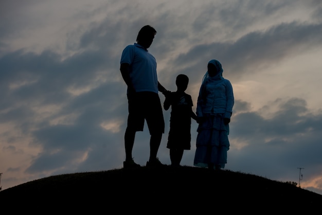 silhouet van gelukkige familie genieten van zichzelf op klif