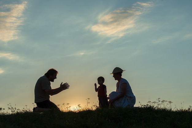 silhouet van gelukkige familie genieten van zichzelf op klif