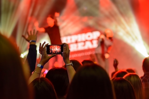 Silhouet van handen met een smartphone tijdens een concert