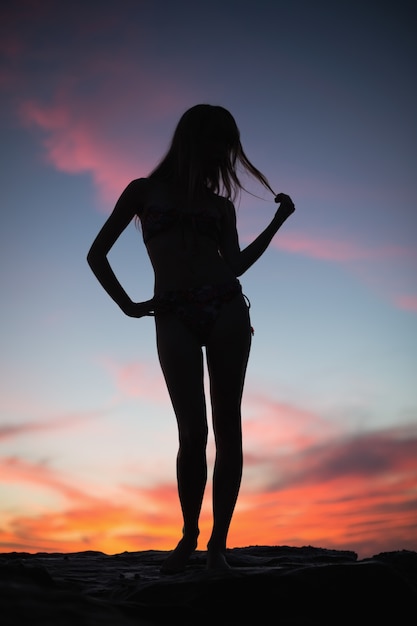 Silhouet van het aantrekkelijke vrouw stellen op het strand