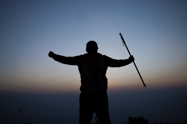 Silhouet van juichende wandelende man met open armen naar de zonsopgang op de berg Reizen Lifestyle reislust avontuur concept zomervakanties buiten