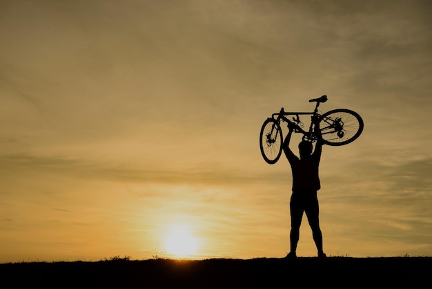 Silhouet van knappe man met fiets op sunsetsport man concept