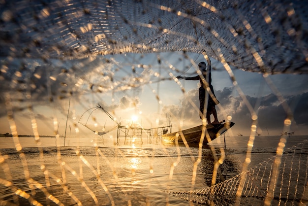 Silhouet van man met visnetten in de ochtend in Pakpra, Phatthalung, Thailand