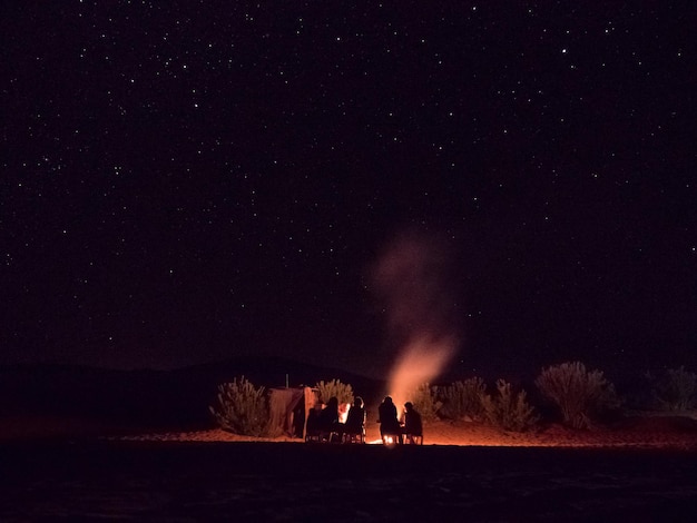Foto silhouet van mensen bij het kampvuur tegen de hemel's nachts