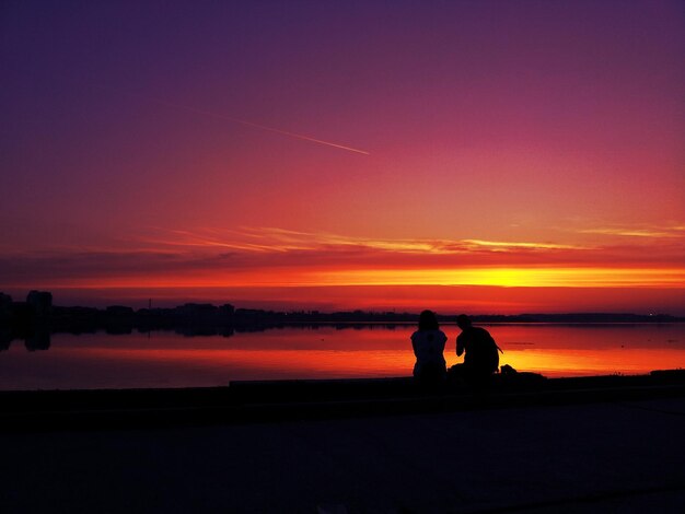 Silhouet van mensen bij zonsondergang