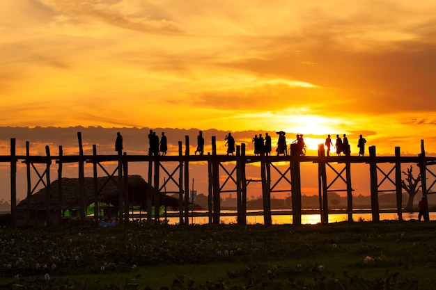 Silhouet van mensen die 's avonds over de U Bein-brug reizen U bein-brug Taungthaman-meer Amarapura Birma