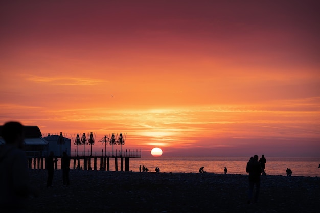 Foto silhouet van mensen op een strand die genieten van de zonsondergang