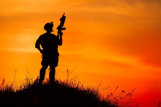 Silhouet van militaire soldaat of officier met wapens bij zonsondergang