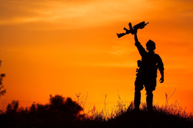 Silhouet van militaire soldaat of officier met wapens bij zonsondergang