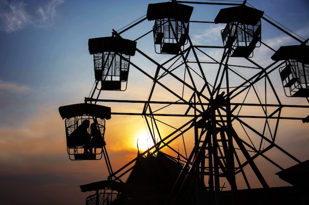 Silhouet Van Minnaar In Het Reuzenrad In De Avond