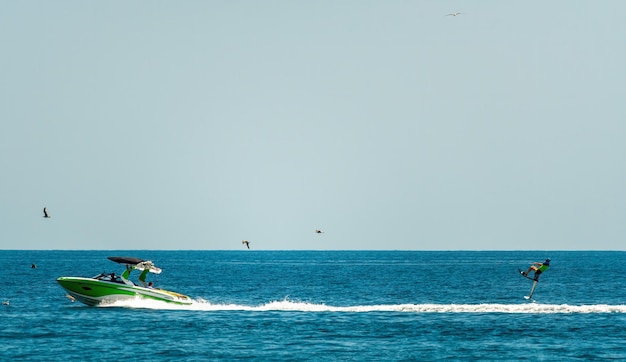 Silhouet van motorboot en wakeboarder springen gekke truc wakeboarder maken trucs op de zee