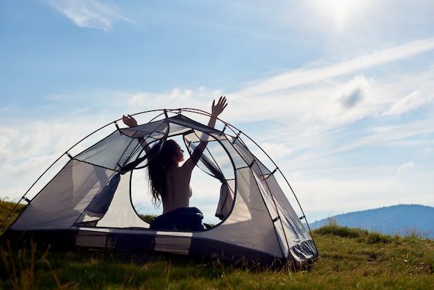 silhouet van naakte vrouw camper zitten in tent